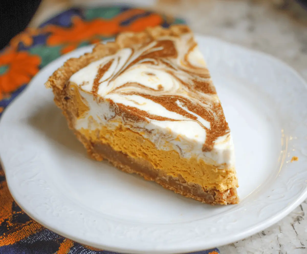 Delicious Pumpkin Cheesecake Swirl Pie with a creamy filling and festive autumn toppings.