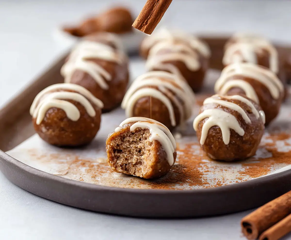 Delicious Cinnamon Roll Protein Bites with creamy frosting and a cinnamon sugar topping.