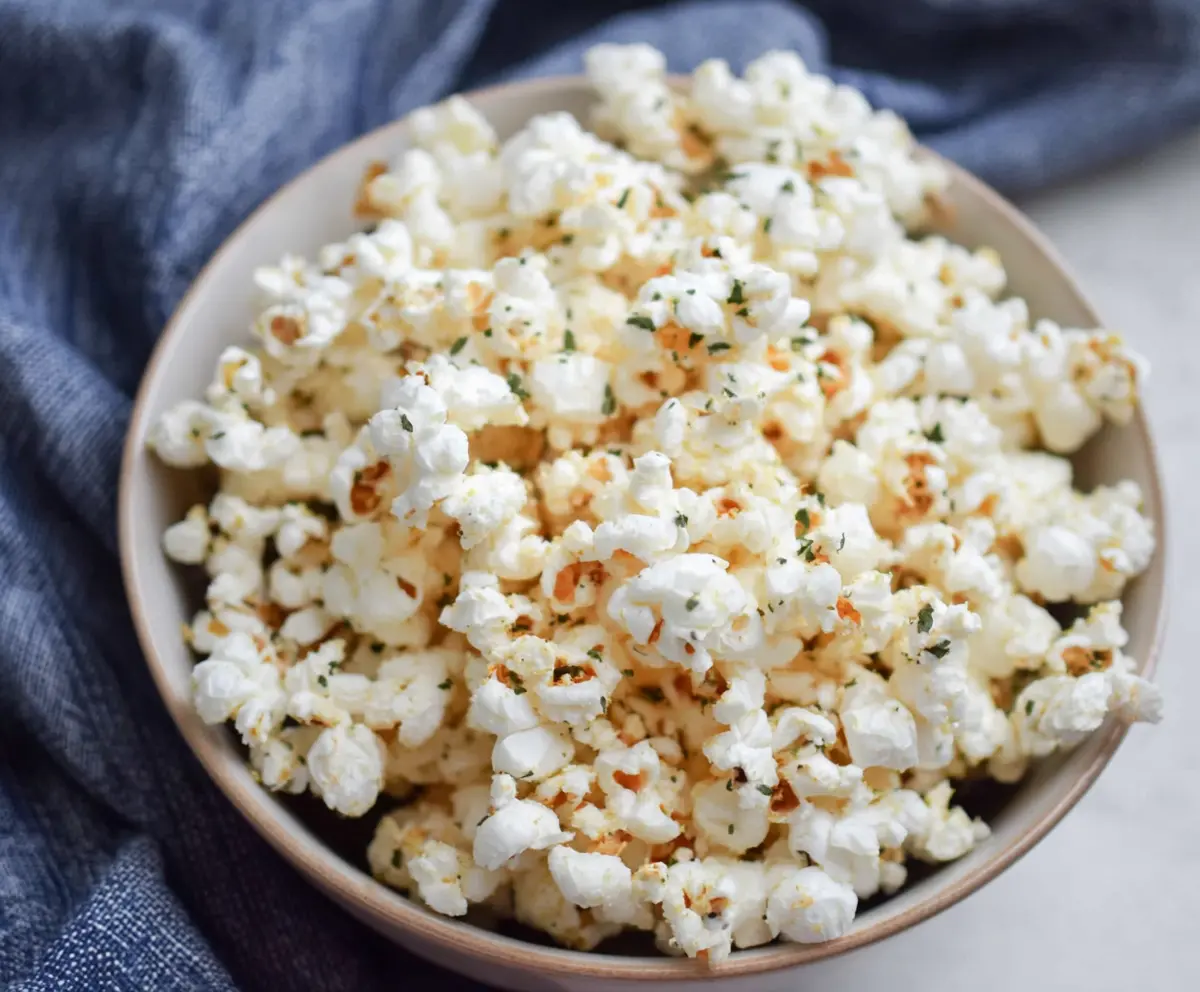 Delicious Parmesan Truffle Popcorn sprinkled with grated cheese and truffle oil, perfect for snacking.