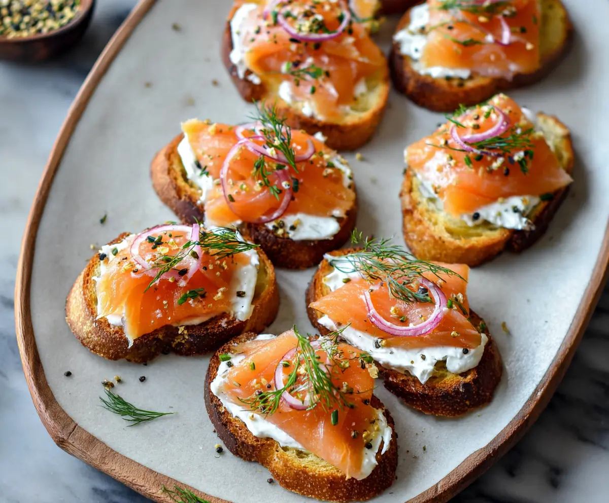 Delicious smoked salmon crostini topped with fresh dill and cream cheese for a gourmet appetizer.