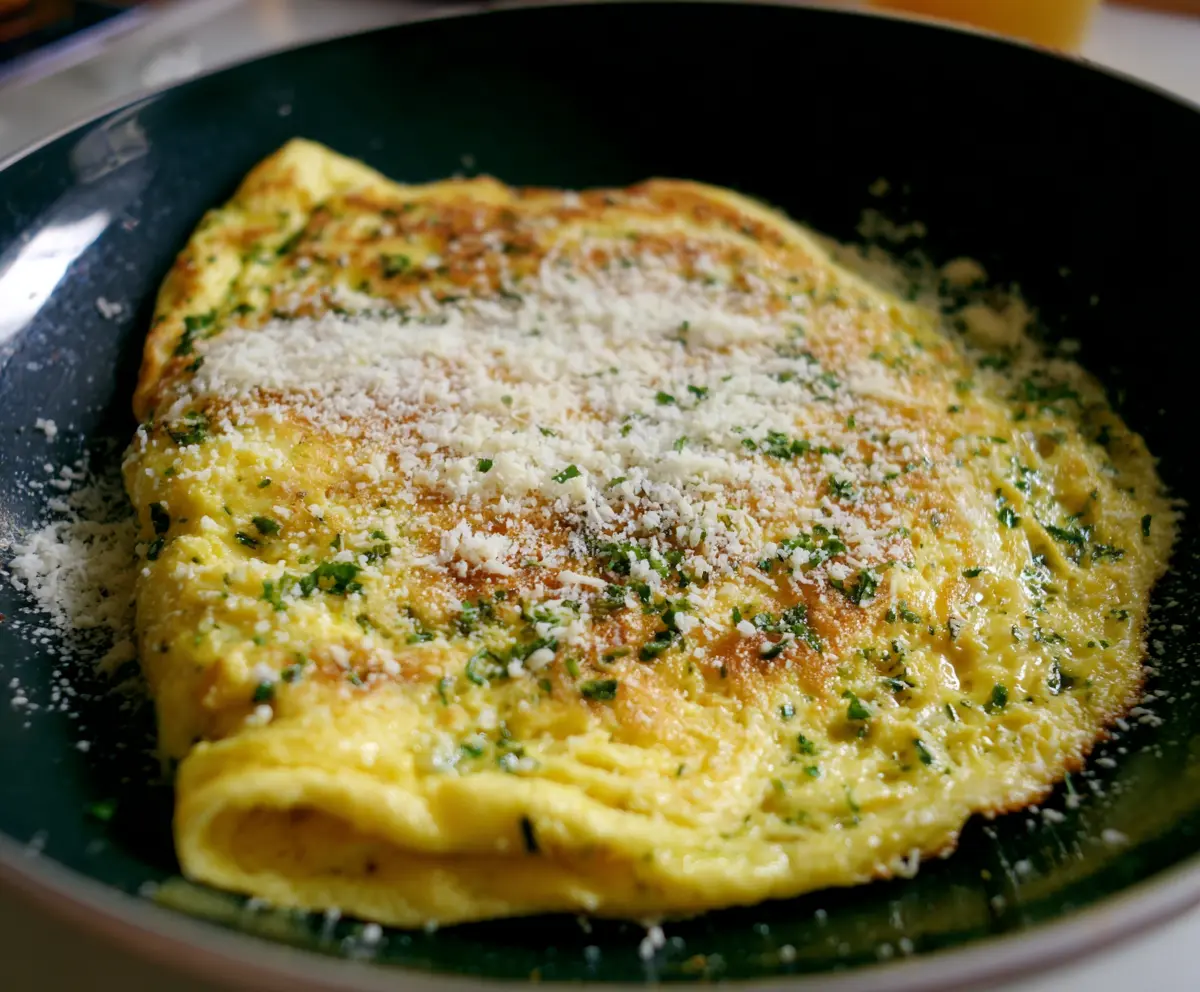 Delicious Parmesan herb omelet garnished with fresh herbs on a breakfast plate